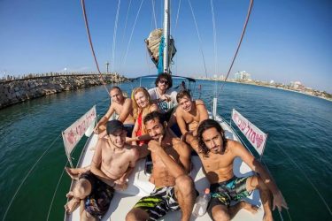 חברים צעירים מבלים ביאכטה בים לרגל יום הולדת